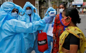 Person wearing mask walking past Covid testing centre in Kolkata during fresh Covid spike.