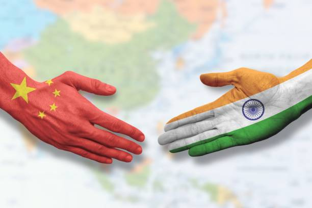 India and China flags with handshake symbolizing diplomatic engagement