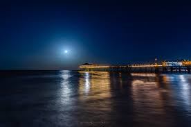 A stunning photo of the Buck Moon rising over a Gulf Coast beach