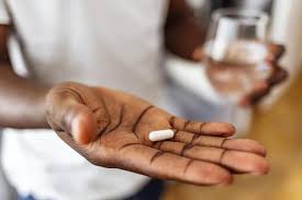 A person contemplating pills and medication.